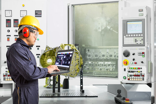 Engineer using laptop computer control automotive part washing machine in automotive industry, Smart factory concept