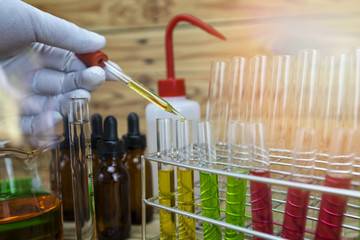 Researcher is dropping the reagent into test tube.Scientist working at the laboratory.