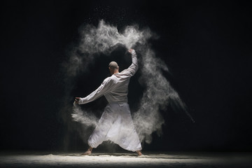 Male doing yoga in white dust cloud rearview