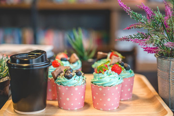 Cupcake strawbery with cream and chocolate  stick on the wood dish, grain, Blueberry, Selective focus