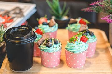 Cupcake strawbery with cream and chocolate  stick on the wood dish, grain, Blueberry, Selective focus