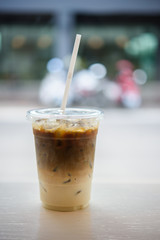 Iced coffee glass on the wood tabel with bokeh light.