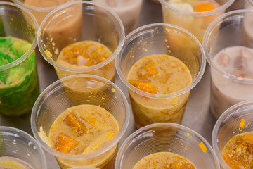 Thai sweetmeat with pumpkin coconut milk in plastic glass, Close up view