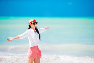 Young beautiful woman on white sand tropical beach. Caucasian girl with hat background the sea