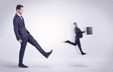 Fototapeta premium Big man kicking little himself out