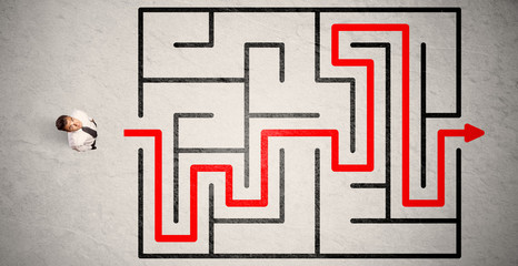 Lost businessman found the way in maze with red arrow