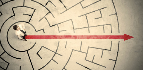 Business person standing in the middle of a circular maze
