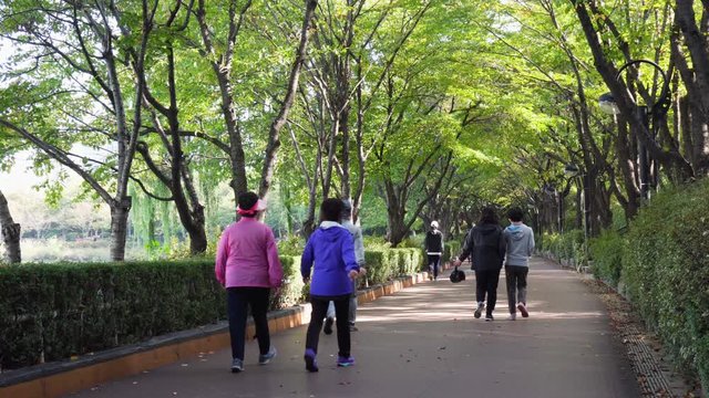 Residents of Seoul jogging and walking in park at downtown