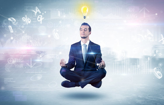 Businessman meditates with enlightenment concept