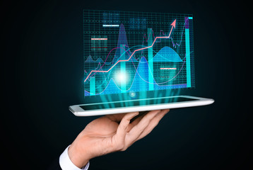 Stock exchange broker with tablet on dark background