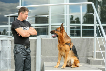 Security guard with dog near building