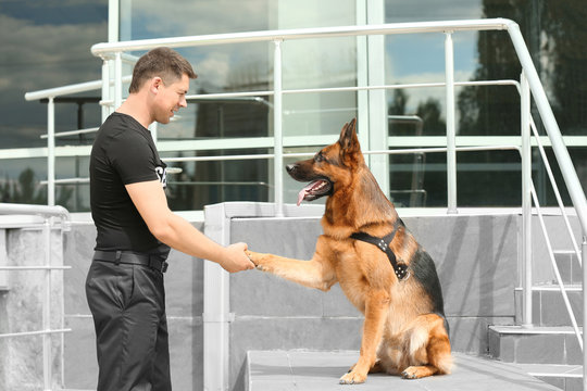 Security guard with dog near building