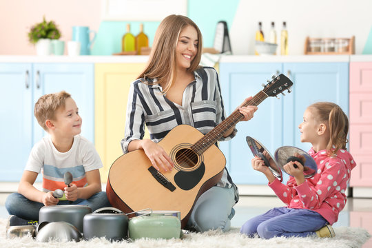 Family Playing With Kitchenware As Musical Band At Home