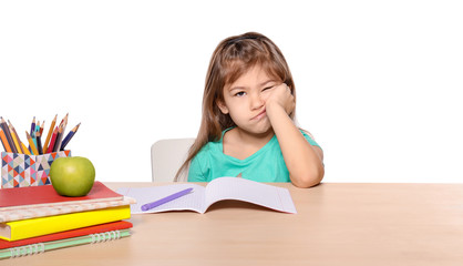 Bored little girl unwilling to do homework against white background