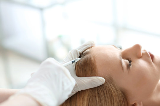 Young woman with hair problem receiving injection in clinic, closeup