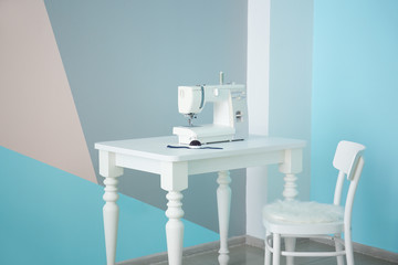 Sewing machine on table in tailor's workshop