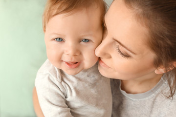 Young mother with her cute little baby at home