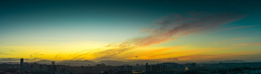 Beautiful natural sunrise  over silhouettes city skyline and amazing orange cloud blue sky above it .