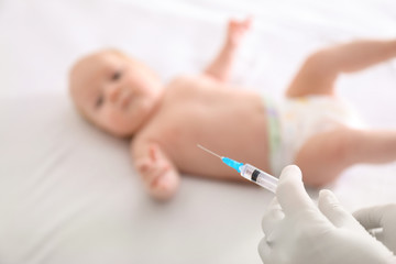 Doctor holding syringe with vaccine for  baby in hospital