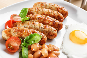 Plate with delicious grilled sausages and fried egg, closeup