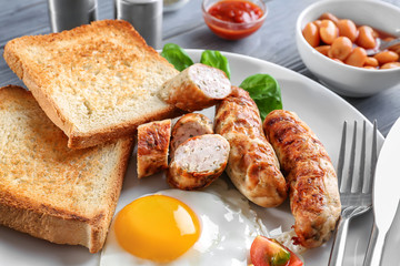 Plate with delicious grilled sausages, toasts and fried egg, closeup