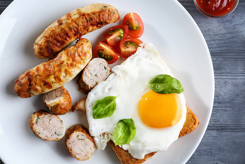 Plate with delicious grilled sausages and fried egg, closeup