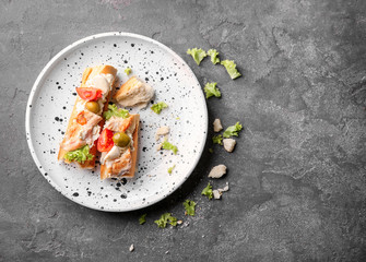 Plate with tasty chicken bruschettas on table
