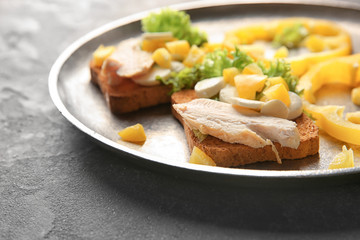Plate with tasty chicken bruschettas on table