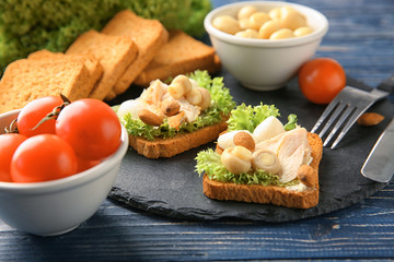 Slate plate with tasty chicken bruschettas and ingredients, closeup
