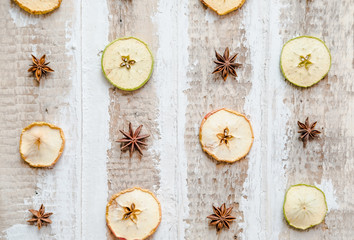 scattered slices of dried apples and star anise, on a wooden surface toned background decoration design