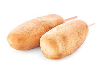 Tasty corn dogs on white background