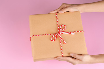 Woman holding parcel on color background