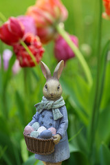 Easter. Easter bunny with a basket of eggs on a  floral tulip background. Easter mood.