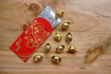 Chinese new year festival decorations ingots, red packet (ang pow) and Malaysian Ringgit banknote...