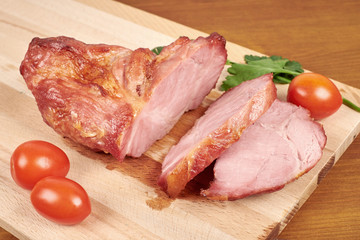Cooked sliced pork barbecue steak on wooden cutting board.