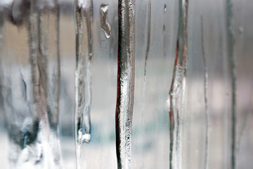 Misted window glass with ice flows. Conceptual view of the house from the outside. 
