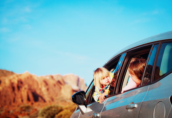 mother and little daughter travel by car in mountains