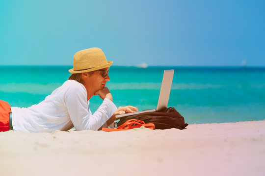 remote work -man with laptop on beach