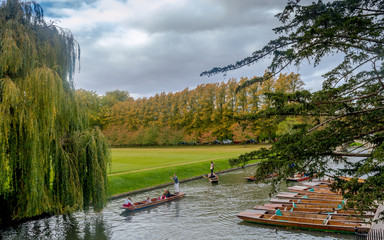 Cambridge, United kingdom - Boats parked in a row and people enjoying punting on river Cam during...