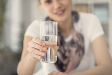 Young woman holding glass of water