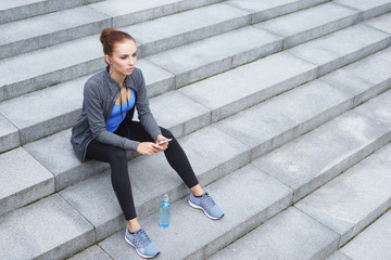 Young, fit and sporty woman resting after the training. Fitness, sport, urban jogging, healthy lifestyle concept.