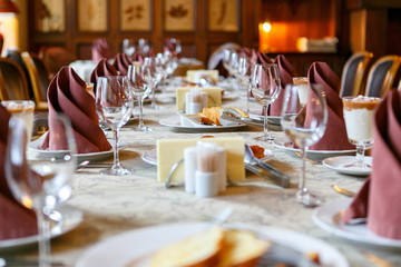 Table setting before the event. Willingness to receive guests. Perspective and lines, neatly before filing. Empty glasses and plates. There are snacks on the table. Beautiful napkin, utensils