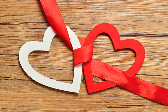 A white and red heart bind together with a red ribbon