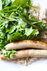 Barley porridge with fresh salad and grilled sausages.