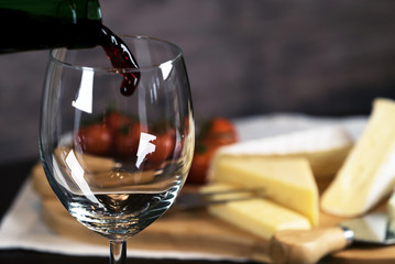 pouring red wine and cheese variety