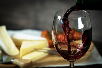 pouring red wine and cheese variety