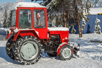 Tractor removing snow from the footpaths in the city park