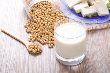 Glass of Soy Milk and Seeds on wooden table.