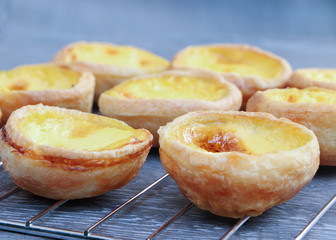 Egg custard tart homemade on metal grille with gray wood background..