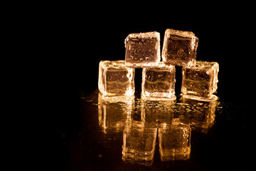 Gold ice cubes on black background.